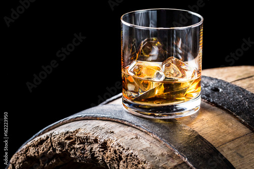 Fotografía Old and tasty brendy with ice on oak barrel