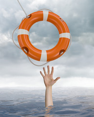 Wall Mural - Man is drowning in ocean and is catching life buoy.