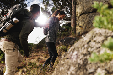 Wall Mural - Happy young couple hiking together in mountain