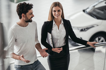 Poster - Salesperson with customer in car dealership