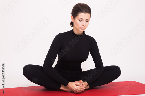 Fotografie, Obraz Beautiful athletic girl in black suit doing yoga asanas