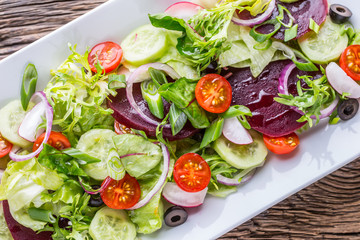 Vegetable salad. Plate of salad with vegetables  on rustic oak table. Assortment of ingredients of vegetable salad.