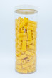 rigatoni pasta in a clear jar with cap, on a white background. 
