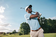 Smiling African American man in cap and sunglasses playing golf