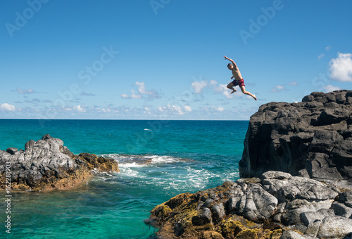 Fototapety skoki do wody  wysportowany-mlody-czlowiek-wskakuje-do-oceanu-na-plazy-lumahai-kauai
