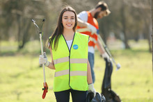 Young Volunteer Picking Up Litter In Park
