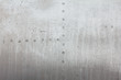 Old aluminum background detail of a military aircraft, surface corrosion.
