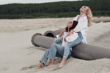 Romantic moment of the two girls are lovers to each other. They sit on the beach and laughing