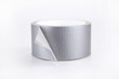 Reel of silver duct tape on a white surface. Roll of duct tape isolated on white background.