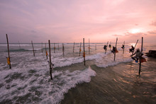 Stilt Fishermen At Sunset Over Ocean
