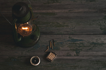 Wall Mural - Old oil lamp, matches and a compass on a wooden background