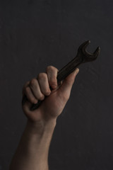 Aufkleber - Man holding wrench on a dark background.