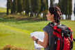 © ZoomTeam - Woman  holding map with backpack in the road and Tuscany background, Relax time on holiday concept travel