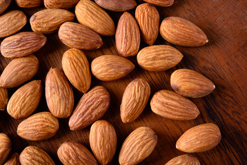 Wall Mural - Almond. Almonds on wooden table. Almonds background. Group of almonds. Peeled almonds. Pile of almonds. Almonds kernel. Almonds nuts.