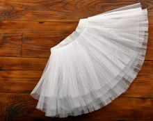White Tutu Skirt On Wooden Background With Empty Space For Text
