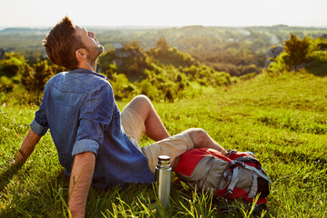 Wall Mural - Middle-aged man relaxing and enjoying the ambience after long hike in the mountains