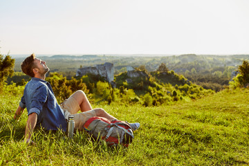 Wall Mural - Man sitting and enjoying the mountainside scenery