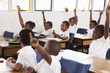 Kids raising hands during a lesson at an elementary school