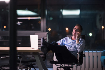 businessman using mobile phone in dark office