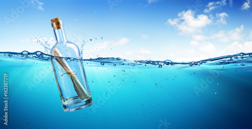 Fotomural Message In Bottle floating In The Ocean