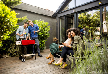 Wall Mural - Friends grilling food and enjoying barbecue party outdoors