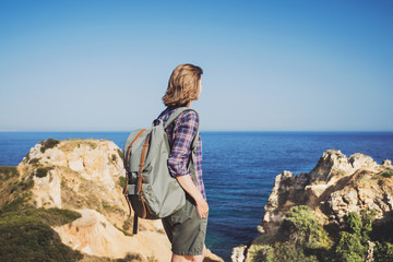 Wall Mural - Woman traveler looking at the sea, travel and active lifestyle concept