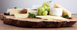 Cheese platter with different cheese on brown wooden plate