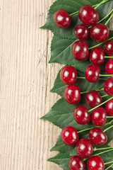 Wall Mural - Berry Cherry with leaves on wooden background