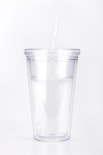 Clear Plastic Tumbler Glass With Lid And Straw On A White Surface. Travel Cup Isolated On White Background.