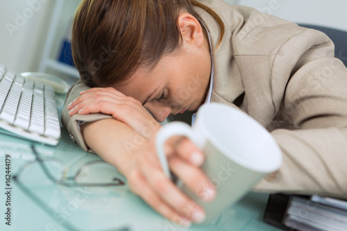 Fotomural exhausted woman sleeping in office after hard working day