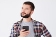 © ArtFamily - Pensive bearded man looking upward while texting on telephone