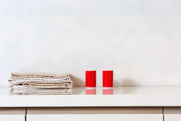 Detail of two cups and kitchen rags on a kitchen countertop.