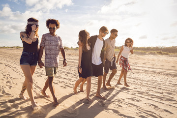 Sticker - Multiethnic group of friends walking on the beach