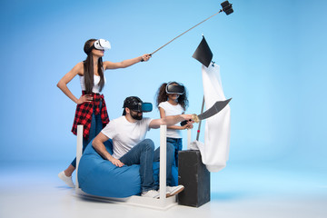 Wall Mural - side view of family in virtual reality headsets pretending being pirates while playing together