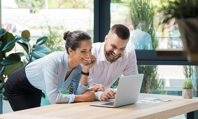 Smiling coworkers working together on new business project in office