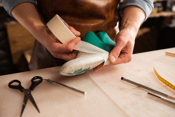 Wall Mural - Close up of a cobbler modeling mens shoe