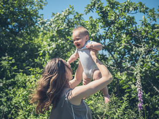 Wall Mural - Mother playing with baby in nature