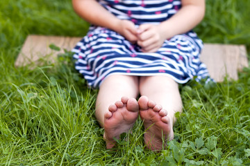 Close up of feet of little girl on green grass