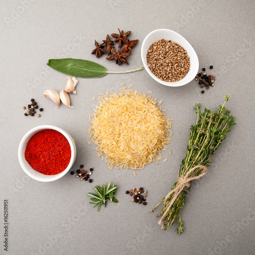 Valokuva Rice groats, spicy herbs and seasonings on a light gray stone table