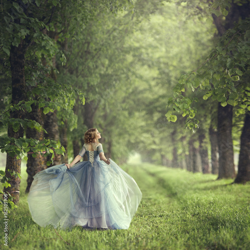 Fotografía Back view of standing young beautiful blonde woman in blue dress