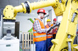 © Westend61 - Three men in factory with industrial robot
