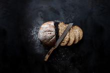 Sliced ​​bread And A Knife Lying On A Black Metal Table