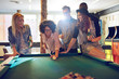 © Flamingo Images - Woman behind the cue ball while friends watch
