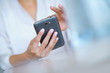 © goodluz - Closeup of woman' s hand using smartphone