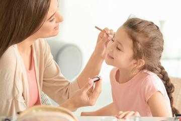 Sticker - Young woman making up her daughter at home