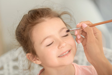 Sticker - Young woman making up her daughter at home