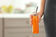 Young woman with bottle of juice at home, closeup. Diet concept