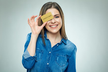 Smiling Young Woman Holding Gold Credit Card Against Her Eye.