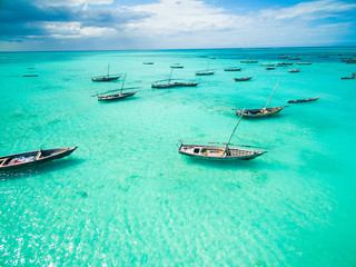 Wall Mural - beautiful colorful seascape with african fishing boats in clear ocean, aerial photo