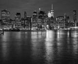 Fototapeta Miasta - Manhattan skyline reflected in East River at night, New York City, USA.